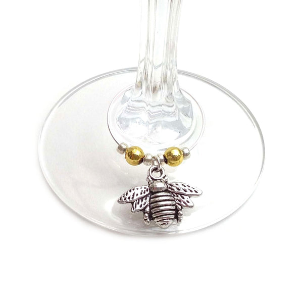 Silver coloured bee wine charm clipped onto wine glass stem