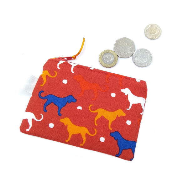 Red purse with multicoloured puppies and cash