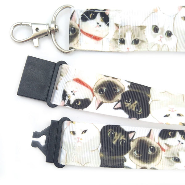 Close up of of black and white cats lanyard showing metal swivel clasp and black plastic safety buckle